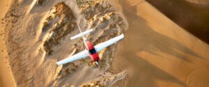 Photos of Cirrus G7 SR Series flying over west coast dunes during fall.